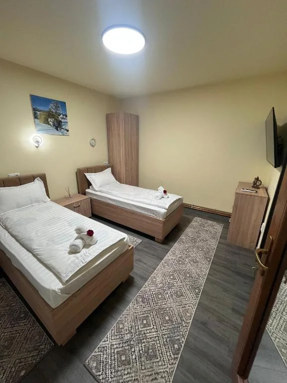 Dormitorul cu două paturi de o persoană din apartamentul Deluxe de 70 m²